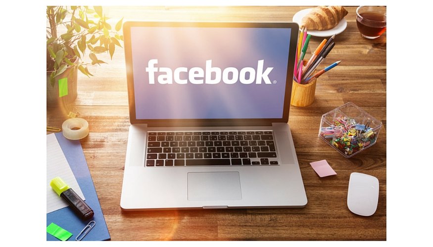 laptop on the desk with the screen showing "facebook"